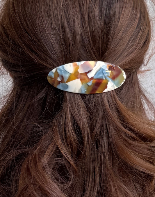 Hair clip with a multicolored design in brown hair